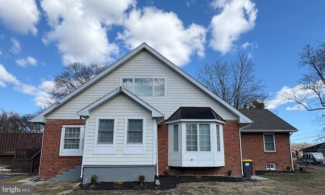 rear view of property with brick siding and a standing seam roof