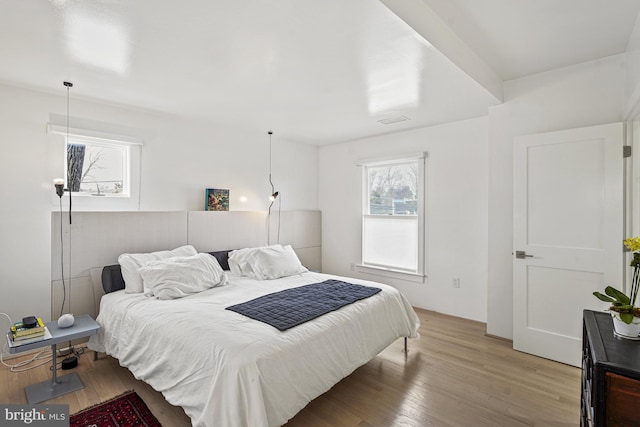 bedroom featuring light wood-style floors and visible vents