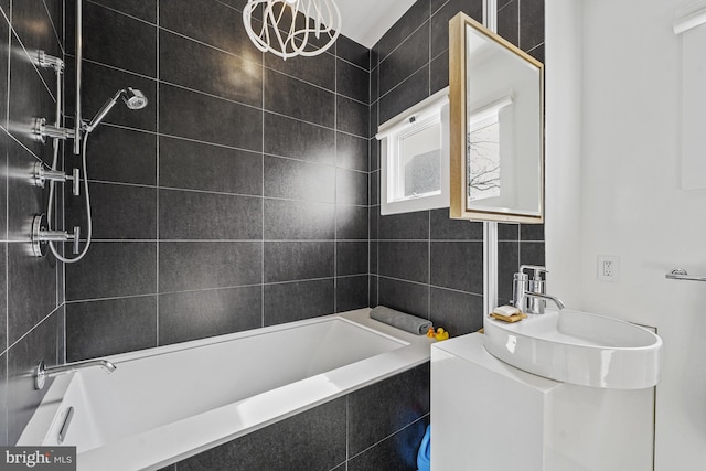 bathroom with shower / tub combination, tile walls, and a sink