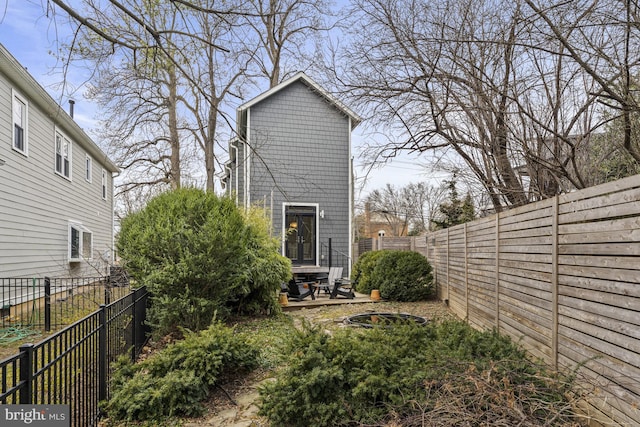 exterior space featuring an outdoor fire pit and a fenced backyard