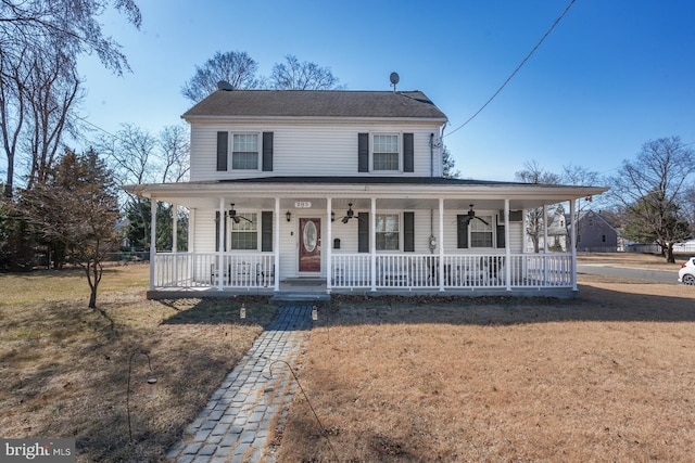 farmhouse featuring covered porch, ceiling fan, and a front yard