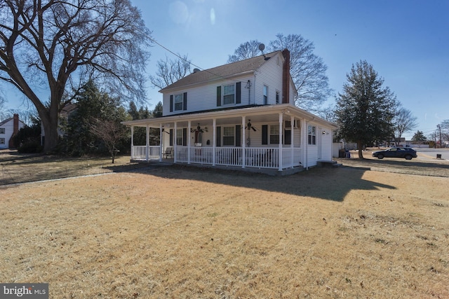 farmhouse-style home featuring ceiling fan, a porch, and a front lawn