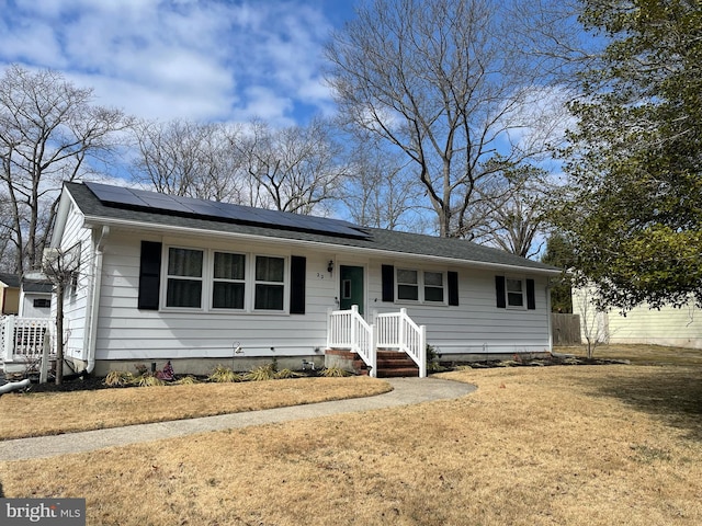 single story home featuring a front lawn and roof mounted solar panels