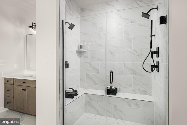 bathroom featuring marble finish floor, a shower stall, and vanity