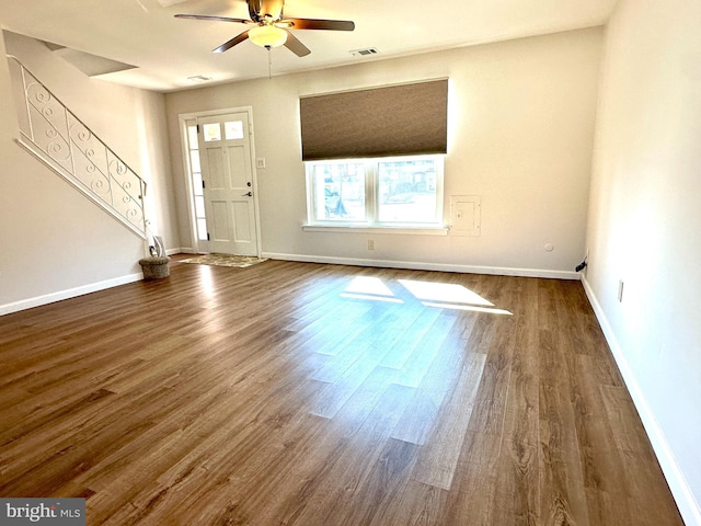 foyer featuring dark wood-style floors, visible vents, ceiling fan, and stairway