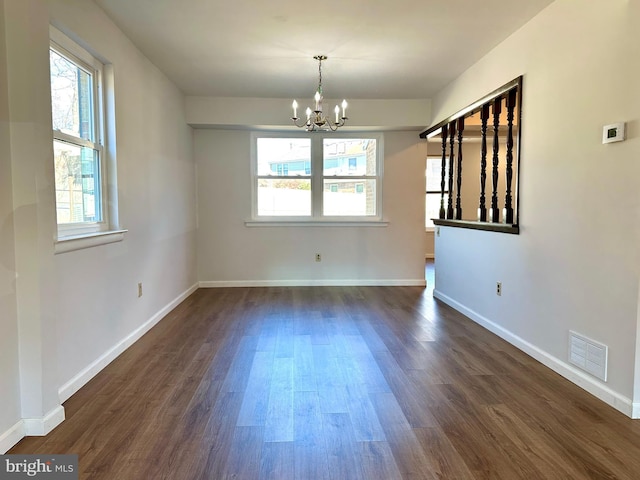 unfurnished dining area with baseboards, dark wood finished floors, visible vents, and a notable chandelier