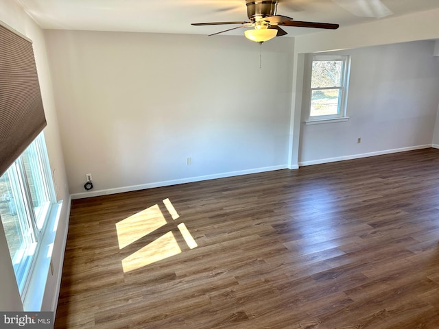 spare room with dark wood-style floors, ceiling fan, and baseboards