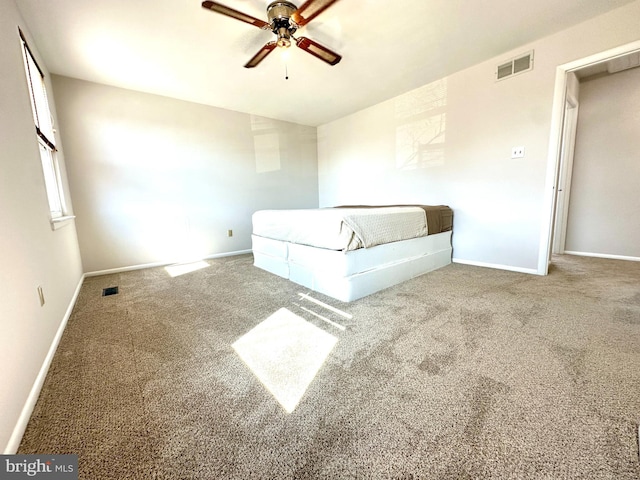 unfurnished bedroom with carpet floors, baseboards, visible vents, and a ceiling fan