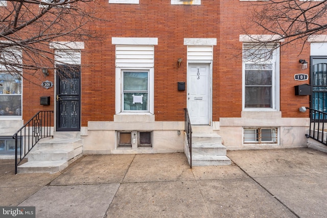 entrance to property featuring brick siding