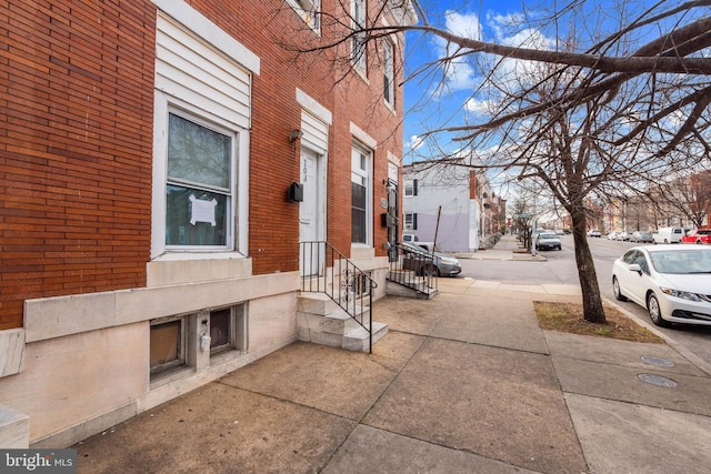 exterior space featuring entry steps, brick siding, and a residential view