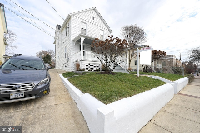 view of front of home featuring covered porch and a front yard