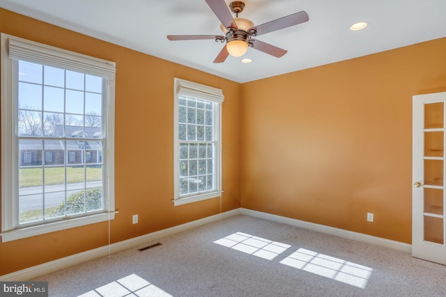 empty room with carpet floors, recessed lighting, visible vents, and baseboards