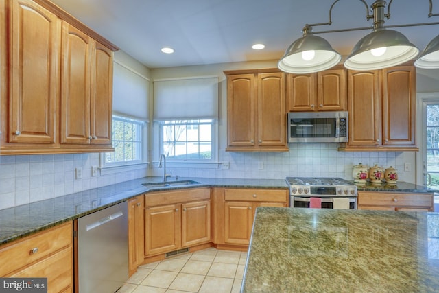 kitchen with visible vents, appliances with stainless steel finishes, dark stone countertops, a sink, and light tile patterned flooring