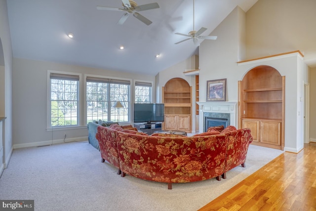 living room featuring a wealth of natural light, a glass covered fireplace, and baseboards