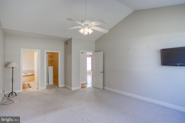 unfurnished bedroom featuring carpet, lofted ceiling, visible vents, a spacious closet, and baseboards