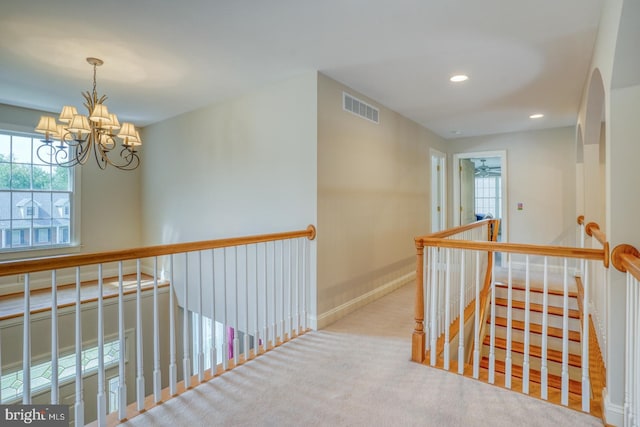 hallway with a chandelier, recessed lighting, carpet floors, an upstairs landing, and visible vents