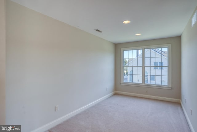 empty room featuring recessed lighting, light colored carpet, visible vents, and baseboards