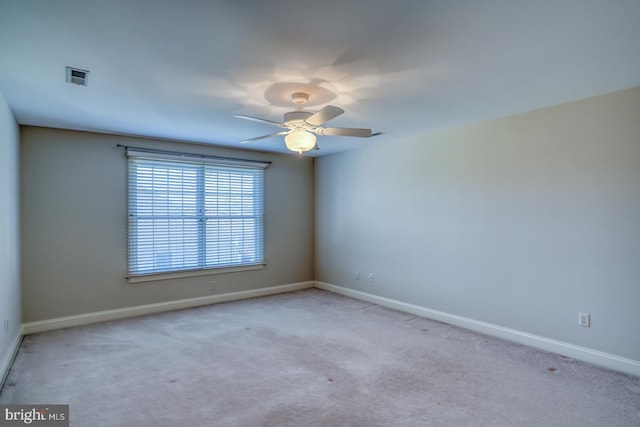 carpeted empty room with visible vents, baseboards, and ceiling fan