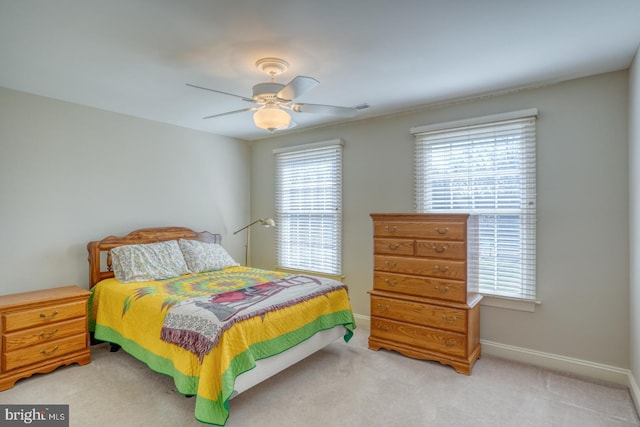 bedroom with visible vents, a ceiling fan, light colored carpet, and baseboards