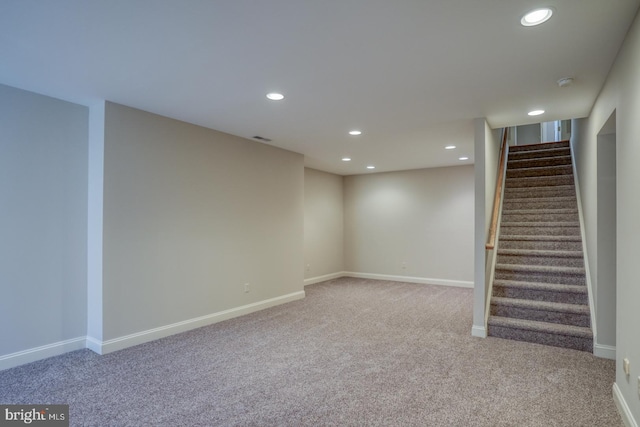 finished below grade area featuring recessed lighting, visible vents, stairway, carpet flooring, and baseboards