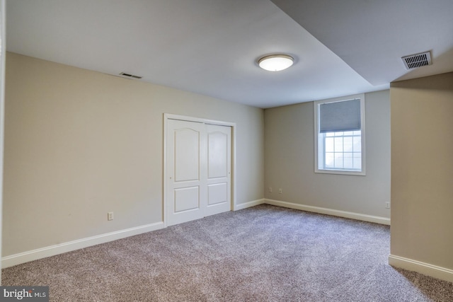 unfurnished bedroom with carpet floors, baseboards, visible vents, and a closet