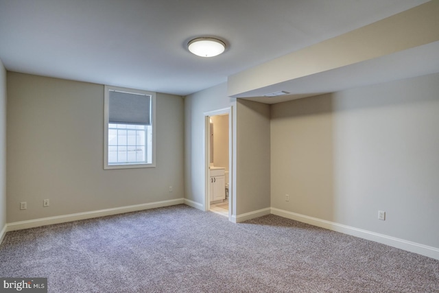 unfurnished bedroom featuring carpet, connected bathroom, and baseboards