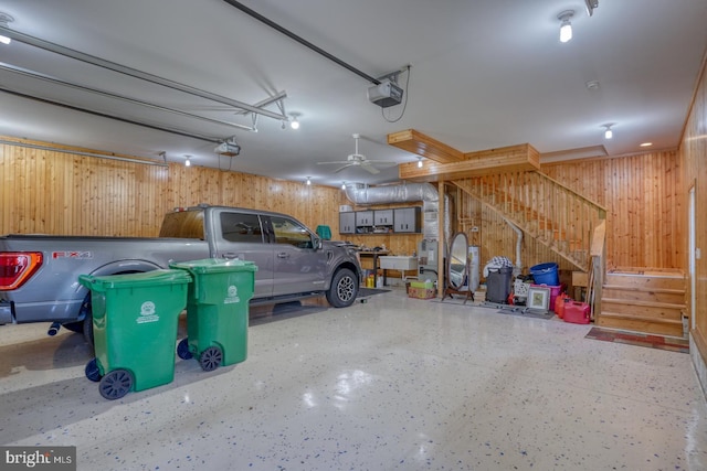 garage featuring a garage door opener and wooden walls