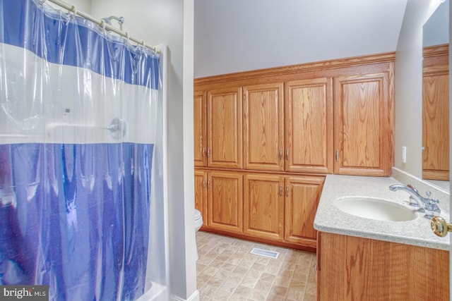 bathroom featuring toilet, curtained shower, vanity, and visible vents