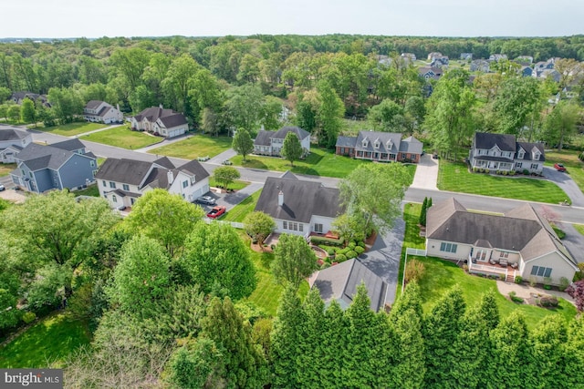 drone / aerial view featuring a residential view and a view of trees