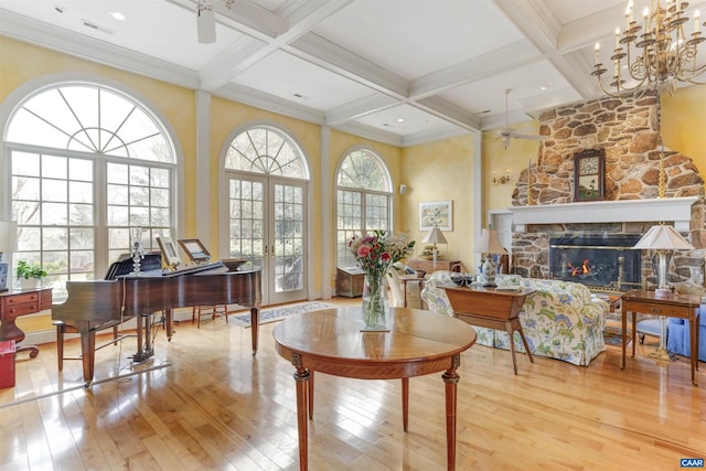 sitting room with wood-type flooring, visible vents, a fireplace, and ceiling fan