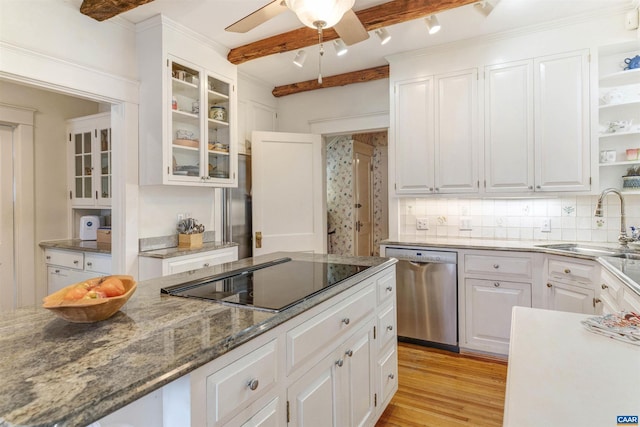 kitchen featuring dishwasher, black electric stovetop, a sink, and white cabinets