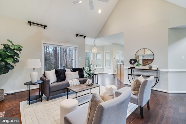 living room featuring high vaulted ceiling, dark wood finished floors, a ceiling fan, and baseboards