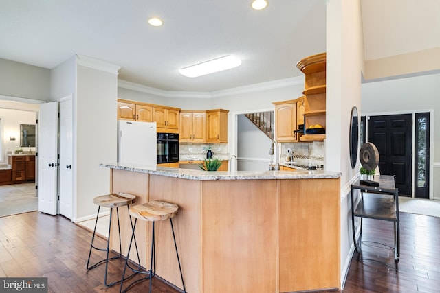 kitchen with a breakfast bar, open shelves, freestanding refrigerator, oven, and a peninsula