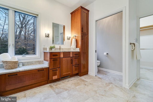 full bathroom featuring toilet, baseboards, and vanity