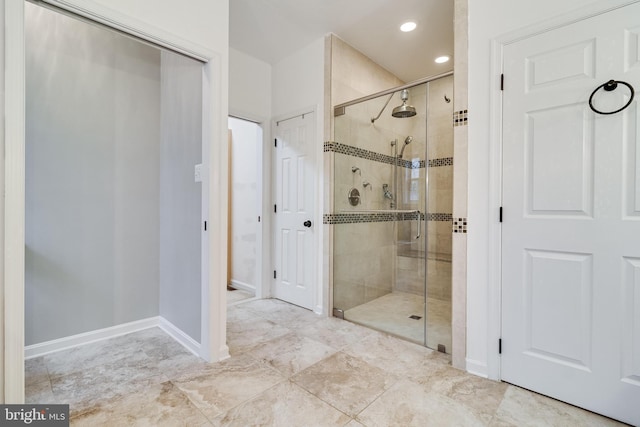 bathroom with recessed lighting, a shower stall, and baseboards