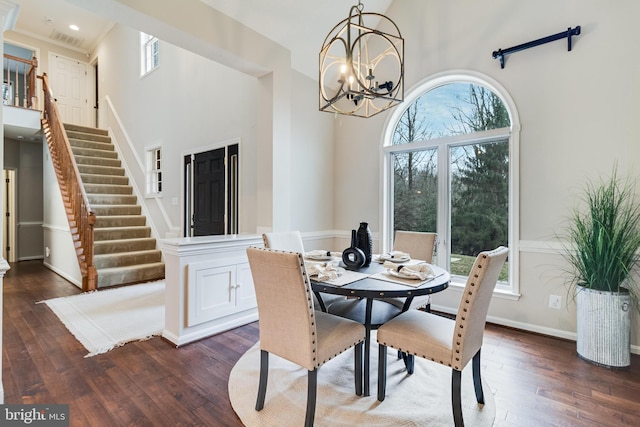 dining room featuring a chandelier, a high ceiling, baseboards, stairway, and dark wood-style floors