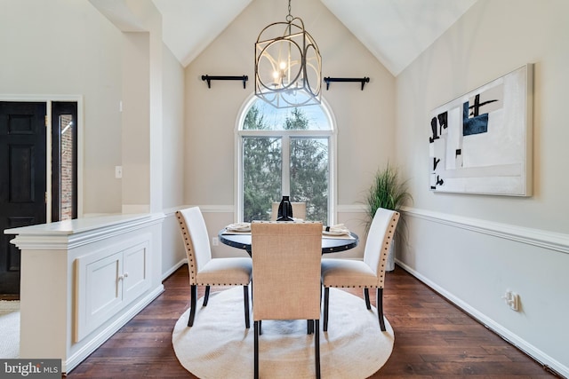 dining area with high vaulted ceiling, an inviting chandelier, baseboards, and dark wood-style flooring