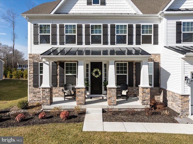 21219 Deckwatch Ln, Frankford, DE 19945 - view of front of property featuring a shingled roof, stone siding, metal roof, a standing seam roof, and a porch