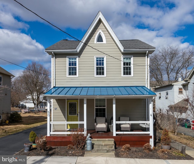 view of front of property featuring a porch, a standing seam roof, roof with shingles, and metal roof