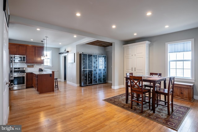 dining room with light wood-style flooring, baseboards, and recessed lighting