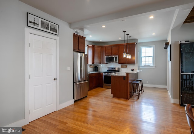 kitchen featuring stainless steel appliances, recessed lighting, light wood-style floors, a peninsula, and a kitchen breakfast bar