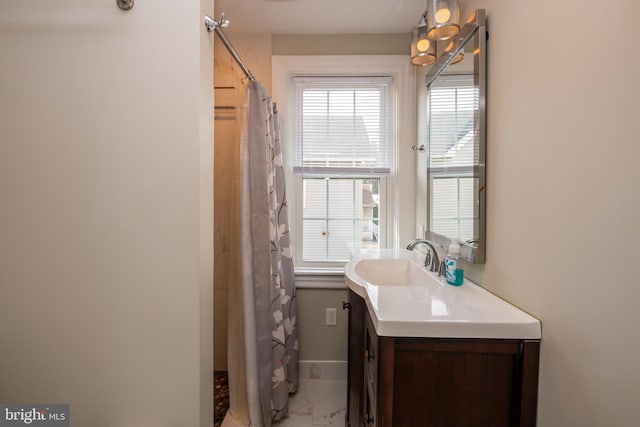 bathroom with marble finish floor, curtained shower, vanity, and baseboards