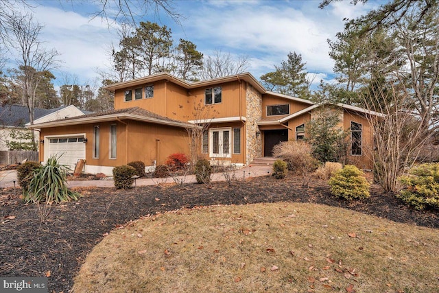 view of front of house featuring stone siding, french doors, and an attached garage