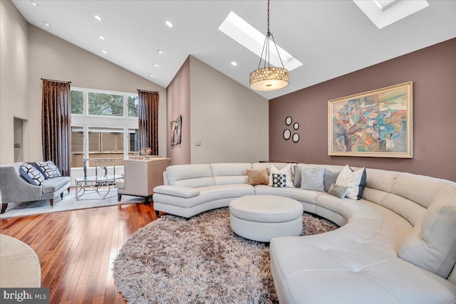 living room featuring high vaulted ceiling, a skylight, recessed lighting, and hardwood / wood-style flooring