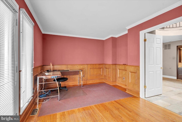 office with a wainscoted wall, crown molding, visible vents, and wood finished floors