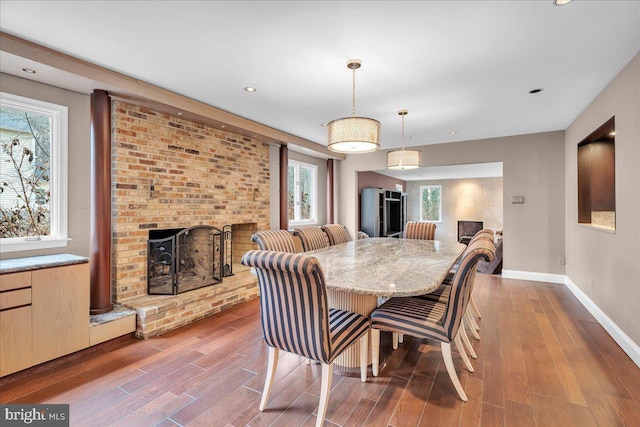 dining area featuring recessed lighting, a brick fireplace, wood finished floors, and baseboards