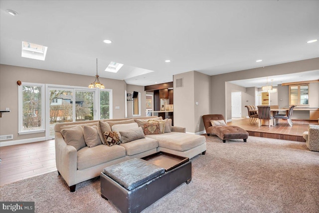 living room with a skylight, baseboards, visible vents, and recessed lighting