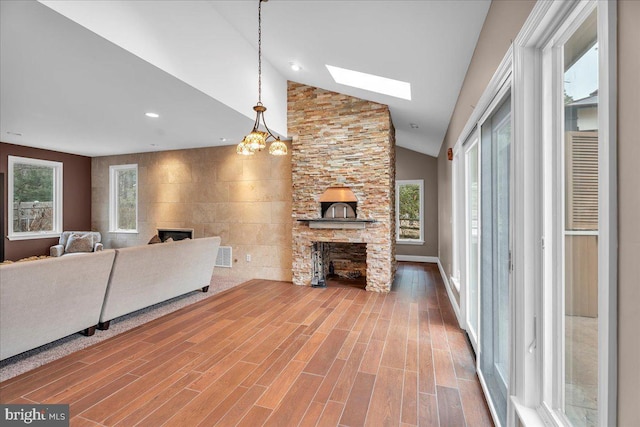 living area with a healthy amount of sunlight, a fireplace, and wood finished floors