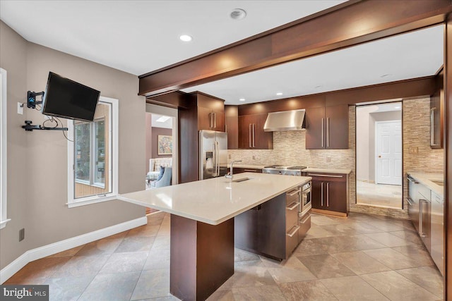 kitchen featuring decorative backsplash, light countertops, stainless steel refrigerator with ice dispenser, and wall chimney exhaust hood