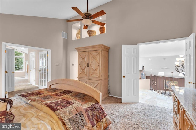 bedroom featuring high vaulted ceiling, light carpet, and visible vents